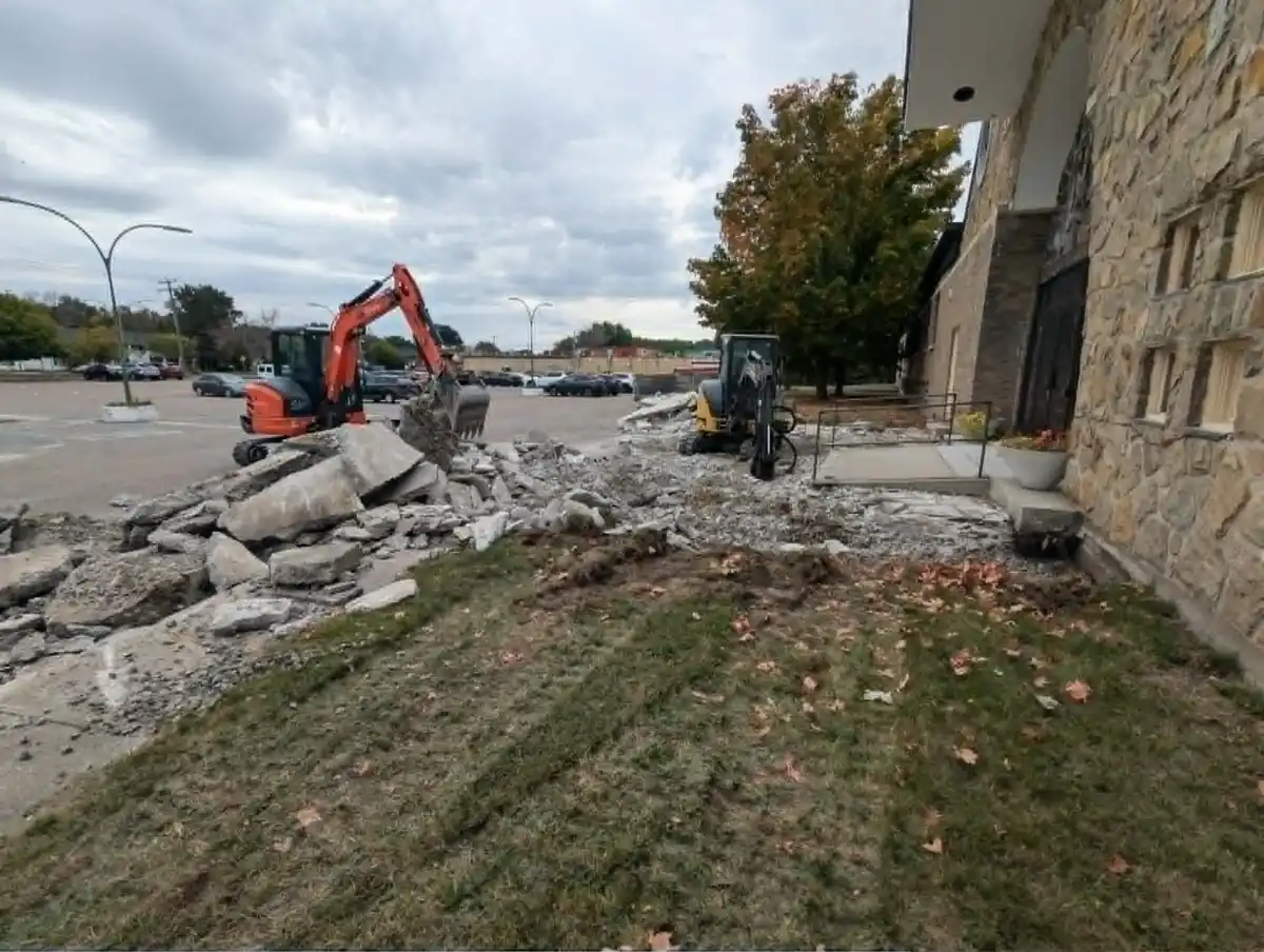Travaux de démolition de béton en secteur commercial avec deux mini-excavatrices