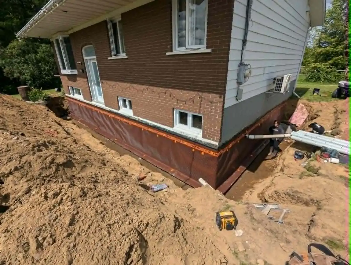 Installation de drain français autour d’une maison résidentielle en brique