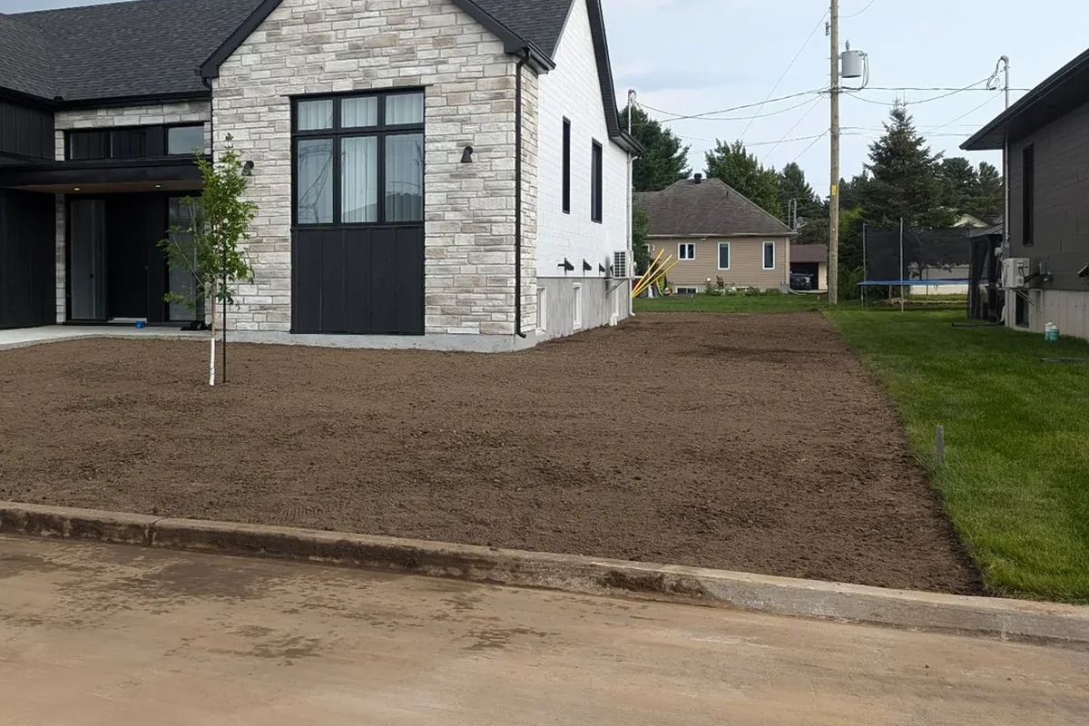 Terrain préparé et nivelé autour d’une entrée résidentielle