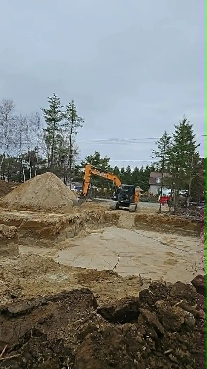 Excavation profonde avec pelle mécanique sur un chantier sableux
