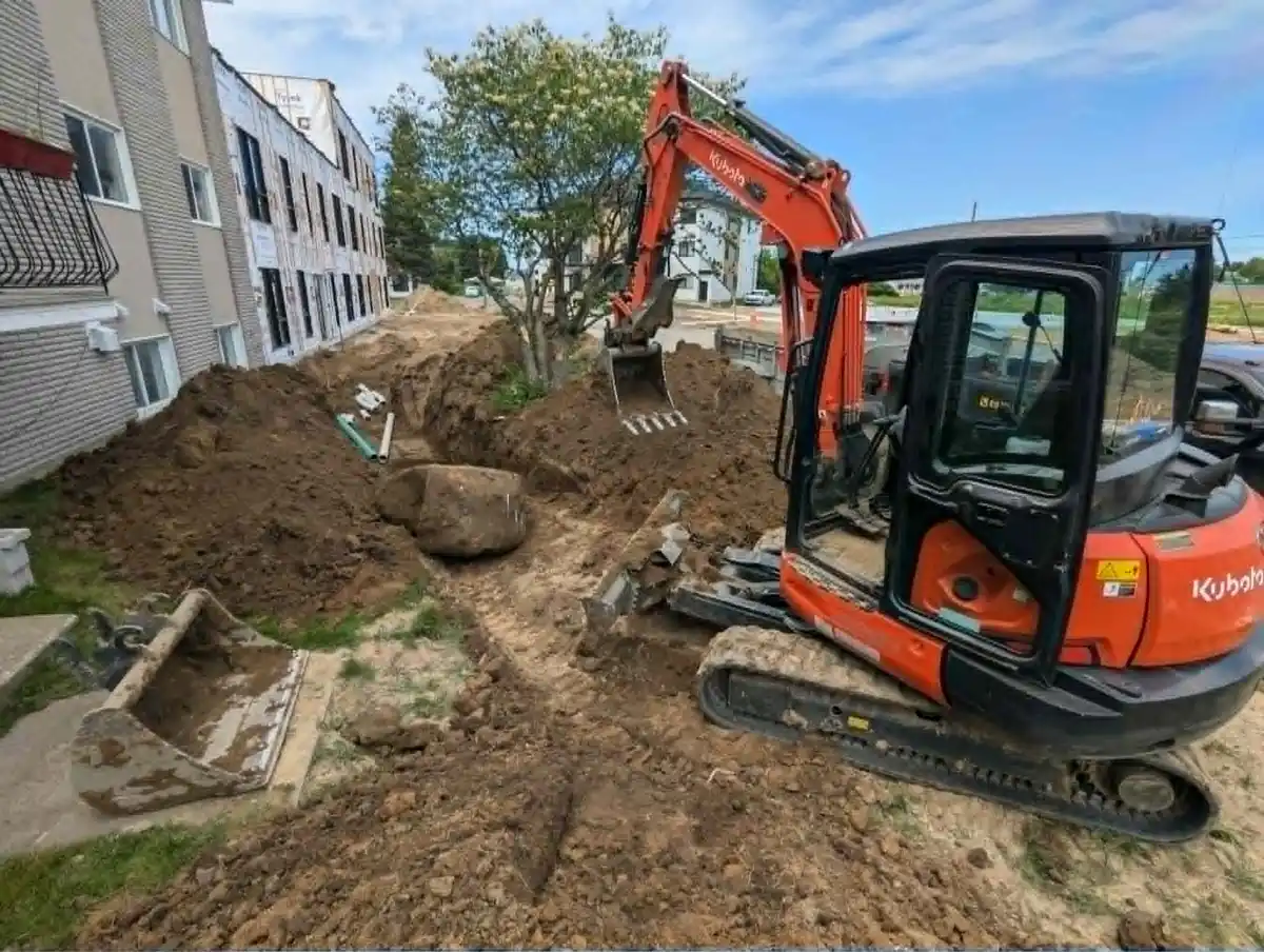 Mini-excavatrice effectuant une tranchée dans un secteur urbain