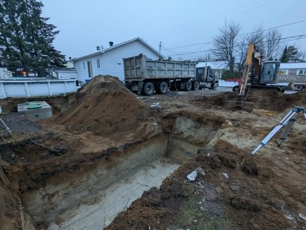 Excavation pour fosse septique avec camion et machinerie en hiver
