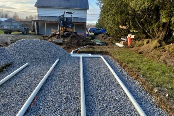 Excavatrice et réseau de conduites sur une base de pierre